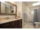 Well-lit bathroom featuring a sink with granite countertops, a modern shower, and a toilet at 18101 Boy Scout Rd, Odessa, FL 33556