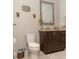 Cozy bathroom featuring a granite-topped vanity, decorative sconces, and a mosaic-framed mirror at 18101 Boy Scout Rd, Odessa, FL 33556