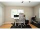 Bedroom with hardwood flooring, ceiling fan, dual monitor desk, and workout equipment by the window at 18101 Boy Scout Rd, Odessa, FL 33556