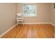 Bright bedroom featuring hardwood floors, neutral walls, and a white chair by a window with backyard views at 18101 Boy Scout Rd, Odessa, FL 33556