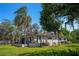 Home exterior showcasing the deck, backyard, and mature landscaping on a sunny day at 18101 Boy Scout Rd, Odessa, FL 33556