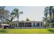 View of the home's back exterior featuring a back deck, palm trees, and screened in porch at 18101 Boy Scout Rd, Odessa, FL 33556