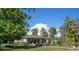 Charming single-story home boasting a covered front porch and inviting landscaping, nestled amidst mature trees and green lawns at 18101 Boy Scout Rd, Odessa, FL 33556