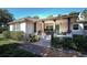 Charming home featuring a covered front porch, adorned with rocking chairs and stone-accented columns at 18101 Boy Scout Rd, Odessa, FL 33556