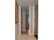 Hallway features marble flooring, neutral walls, and white trim with a partial view of the hardwood bedroom beyond at 18101 Boy Scout Rd, Odessa, FL 33556