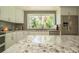 Well-lit kitchen boasting granite countertops, stainless steel appliances, ample storage space and a picturesque view at 18101 Boy Scout Rd, Odessa, FL 33556