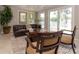 Spacious living room with a leather couch, area rug, and views of the pond, offering a relaxing and inviting space at 18101 Boy Scout Rd, Odessa, FL 33556
