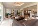 Open-concept living room with a modern chandelier, plush seating, and seamless transition to the kitchen area at 18101 Boy Scout Rd, Odessa, FL 33556