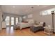 Sunlit main bedroom with wood floors, a chaise lounge, and access to a patio through French doors at 18101 Boy Scout Rd, Odessa, FL 33556
