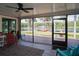 Screened porch overlooking a lake featuring a hammock and seating with a decorative rug and a ceiling fan at 18101 Boy Scout Rd, Odessa, FL 33556