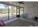 Screened porch overlooking a lake with outdoor seating, a decorative rug, and brick accent wall at 18101 Boy Scout Rd, Odessa, FL 33556