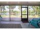 Screened porch overlooking a lake with outdoor seating and a hammock, with a decorative rug and tile flooring at 18101 Boy Scout Rd, Odessa, FL 33556