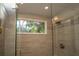 Modern shower with glass doors and a window at 18101 Boy Scout Rd, Odessa, FL 33556