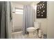 Functional bathroom space includes a toilet, shower with a curtain, and a decorative wall hanging at 18101 Boy Scout Rd, Odessa, FL 33556