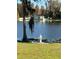 Beautiful lakefront property featuring a white statue on a concrete plinth, with a home in the background at 18101 Boy Scout Rd, Odessa, FL 33556