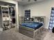 Charming bedroom with a themed bed, organized closet, complemented by patterned curtains and plush carpeting at 2518 Sunset Ln, Lutz, FL 33559