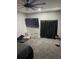 Cozy bedroom with a large wall-mounted TV, a pet bed, and blackout curtains, perfect for restful relaxation at 2518 Sunset Ln, Lutz, FL 33559