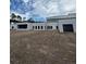 Modern white home featuring a sleek design, expansive windows, and a spacious, unfinished front yard at 2518 Sunset Ln, Lutz, FL 33559