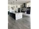 Spacious kitchen with black appliances, modern white and black cabinetry, and a large island at 2518 Sunset Ln, Lutz, FL 33559