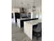 Modern kitchen featuring white and black cabinets, double islands with quartz counters, and stainless steel appliances at 2518 Sunset Ln, Lutz, FL 33559
