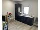A kitchenette with sleek, dark cabinetry, a stainless steel sink, and modern countertops, adjacent to a play area at 2518 Sunset Ln, Lutz, FL 33559