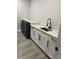 This laundry room features a utility sink, storage, sleek cabinets and modern appliances at 2518 Sunset Ln, Lutz, FL 33559