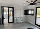 Modern living room featuring gray floors, white walls, and access to an outdoor balcony with sliding doors at 2518 Sunset Ln, Lutz, FL 33559
