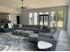Bright living room with a large sectional, big windows, and modern ceiling fan at 2518 Sunset Ln, Lutz, FL 33559