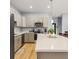 Bright kitchen featuring an island with quartz countertops, modern appliances, and neutral gray cabinetry at 5479 S Biscayne Dr, North Port, FL 34287