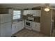 Well-lit kitchen with white appliances and cabinets, complemented by tile flooring and a window at 9202 Teak St, New Port Richey, FL 34654