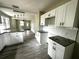 Bright kitchen with white cabinets, granite countertops, and sleek gray flooring at 5117 16Th Ave, Gulfport, FL 33707