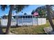 Backyard and pool deck with a tall white fence surrounding the area and an American flag waving at 891 Island Way, Clearwater Beach, FL 33767