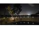Waterfront backyard view with palm trees, a fenced pool, and lights for evening ambiance at 891 Island Way, Clearwater Beach, FL 33767