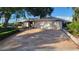 Inviting single-story home with a two-car garage and a well-maintained front yard with mature trees and stone-paved driveway at 891 Island Way, Clearwater Beach, FL 33767