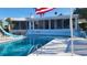 Back of home with a refreshing in-ground pool with blue slide and a glass encased home exterior with steps to a backyard at 891 Island Way, Clearwater Beach, FL 33767
