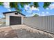 View of detached garage with a black door and a gray metal fence at 4444 5Th S Ave, St Petersburg, FL 33711