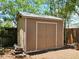 The shed in the backyard has a neutral paint scheme and double doors for easy access at 917 E 15Th Ave, Tampa, FL 33605