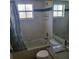 Bright bathroom with a shower-tub combo, white tiling, granite countertop and a large frameless mirror at 4611 Herman Cir, Port Charlotte, FL 33948
