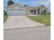 Single-story home featuring an attached garage, well-maintained lawn and an arched front entryway at 4611 Herman Cir, Port Charlotte, FL 33948
