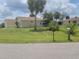 Well-maintained home with a green lawn, mature trees, and a peaceful neighborhood setting at 4611 Herman Cir, Port Charlotte, FL 33948