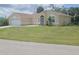 Inviting single-story home with an attached two-car garage and a well-manicured lawn, perfect for families at 4611 Herman Cir, Port Charlotte, FL 33948