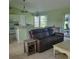 Open-concept living room with tile flooring, light green walls, a comfortable leather sofa, and modern lighting at 4611 Herman Cir, Port Charlotte, FL 33948