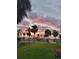 Picturesque sunset over a tranquil neighborhood with palm trees and well-maintained homes at 4611 Herman Cir, Port Charlotte, FL 33948