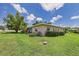 Lush backyard featuring mature trees and well-maintained lawn providing serene outdoor space at 6948 W Country Club N Dr, Sarasota, FL 34243