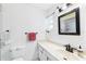 This full bath features a sliding glass door on the shower, bright lighting, and white fixtures at 6948 W Country Club N Dr, Sarasota, FL 34243