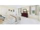 Sunny bedroom with windows, neutral walls, plush carpet, and ensuite bath at 6948 W Country Club N Dr, Sarasota, FL 34243