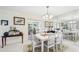 Bright dining room features a modern table setting, large mirror, and access to the outdoor patio area at 6948 W Country Club N Dr, Sarasota, FL 34243