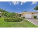 Charming home exterior with a two-car garage, manicured lawn and lush landscaping at 6948 W Country Club N Dr, Sarasota, FL 34243