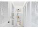 Hallway leading to bathroom with white cabinets and tiled floor at 6948 W Country Club N Dr, Sarasota, FL 34243