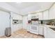 Bright kitchen with white cabinets, tile floors, and stainless steel trash can at 6948 W Country Club N Dr, Sarasota, FL 34243